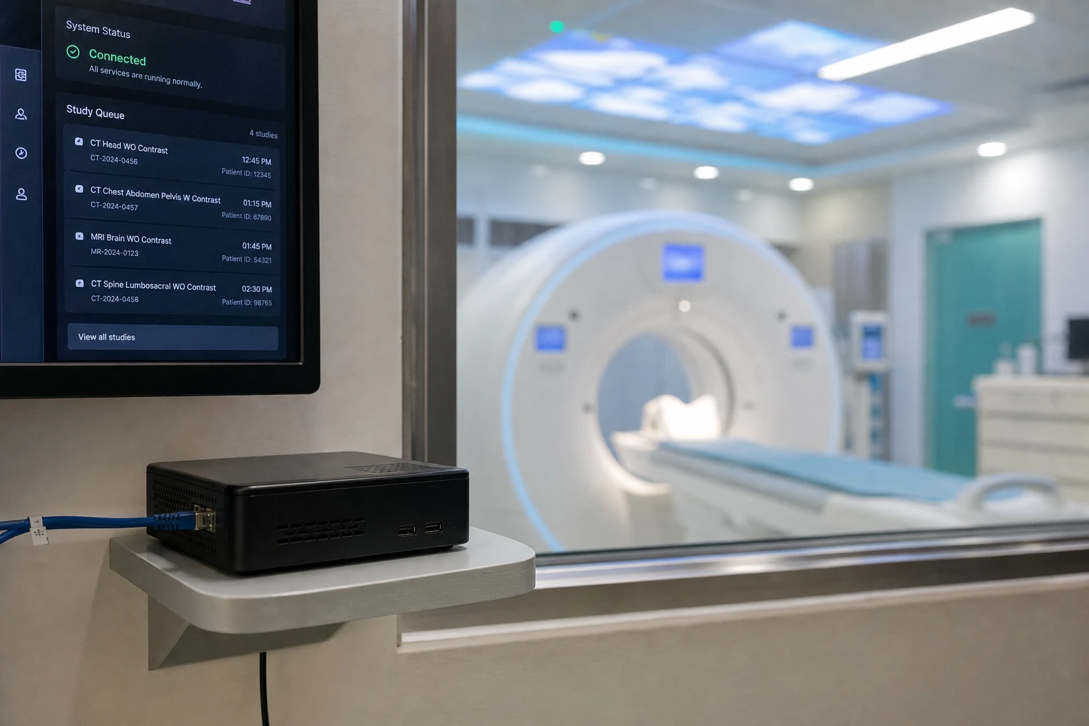 Compact Windows PC running MediLinkFilm Router beside a CT scanner room
